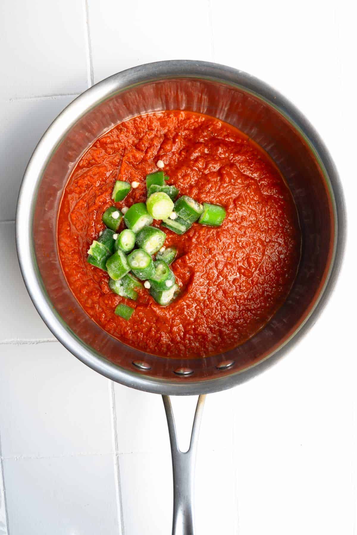 Frozen okra tomato sauce in a saucepan.
