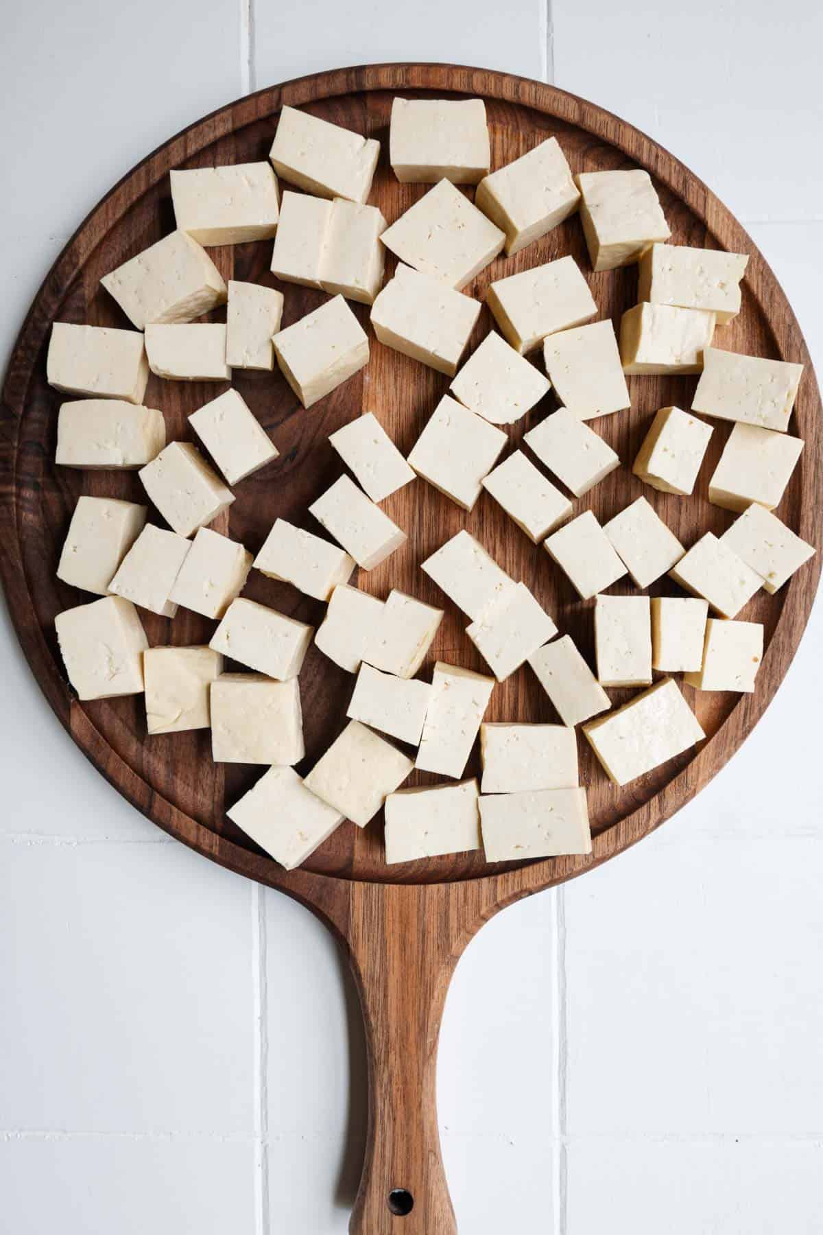 Cubed tofu on a cutting board.