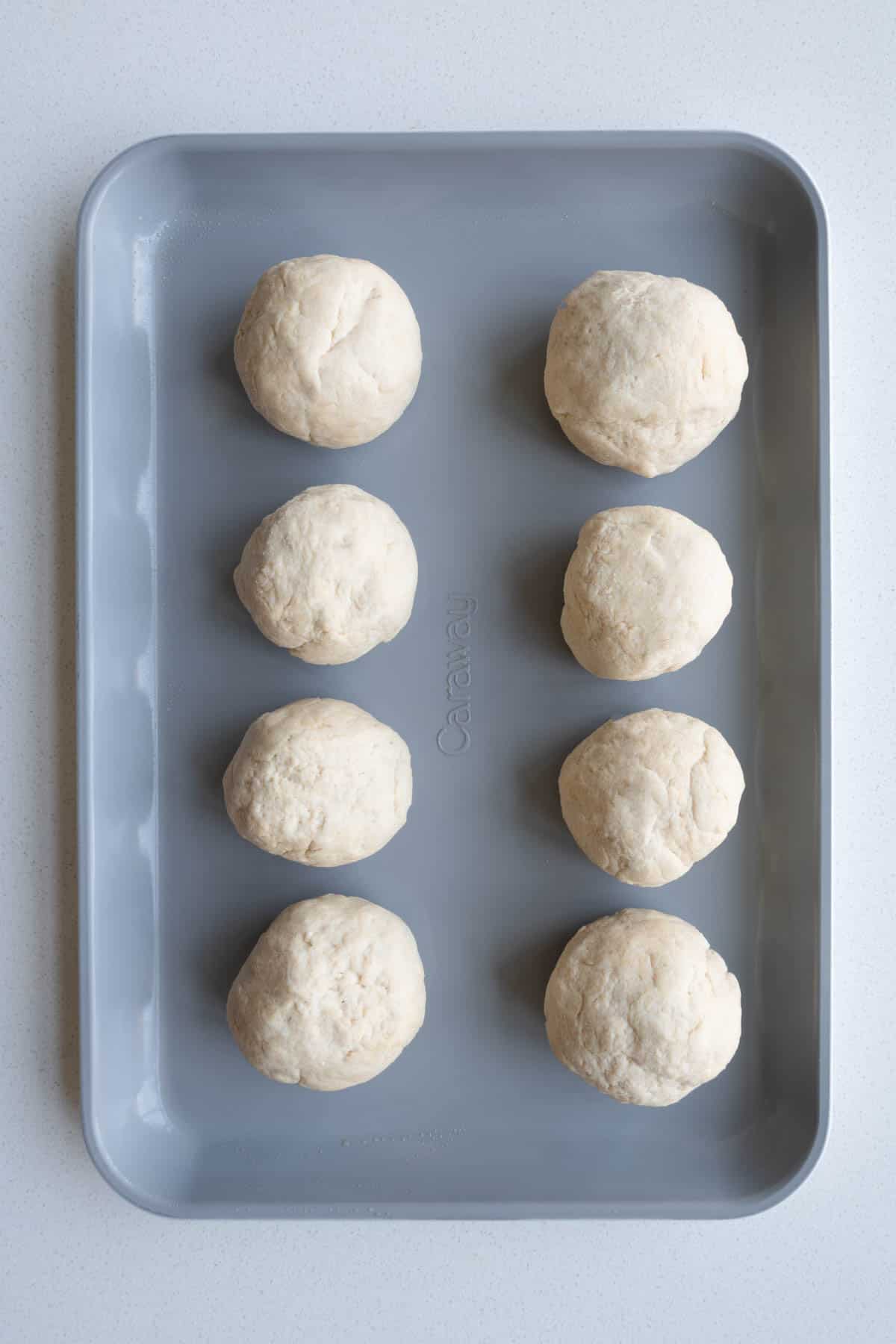Dough rolled for high-protein dinner rolls on a baking sheet.