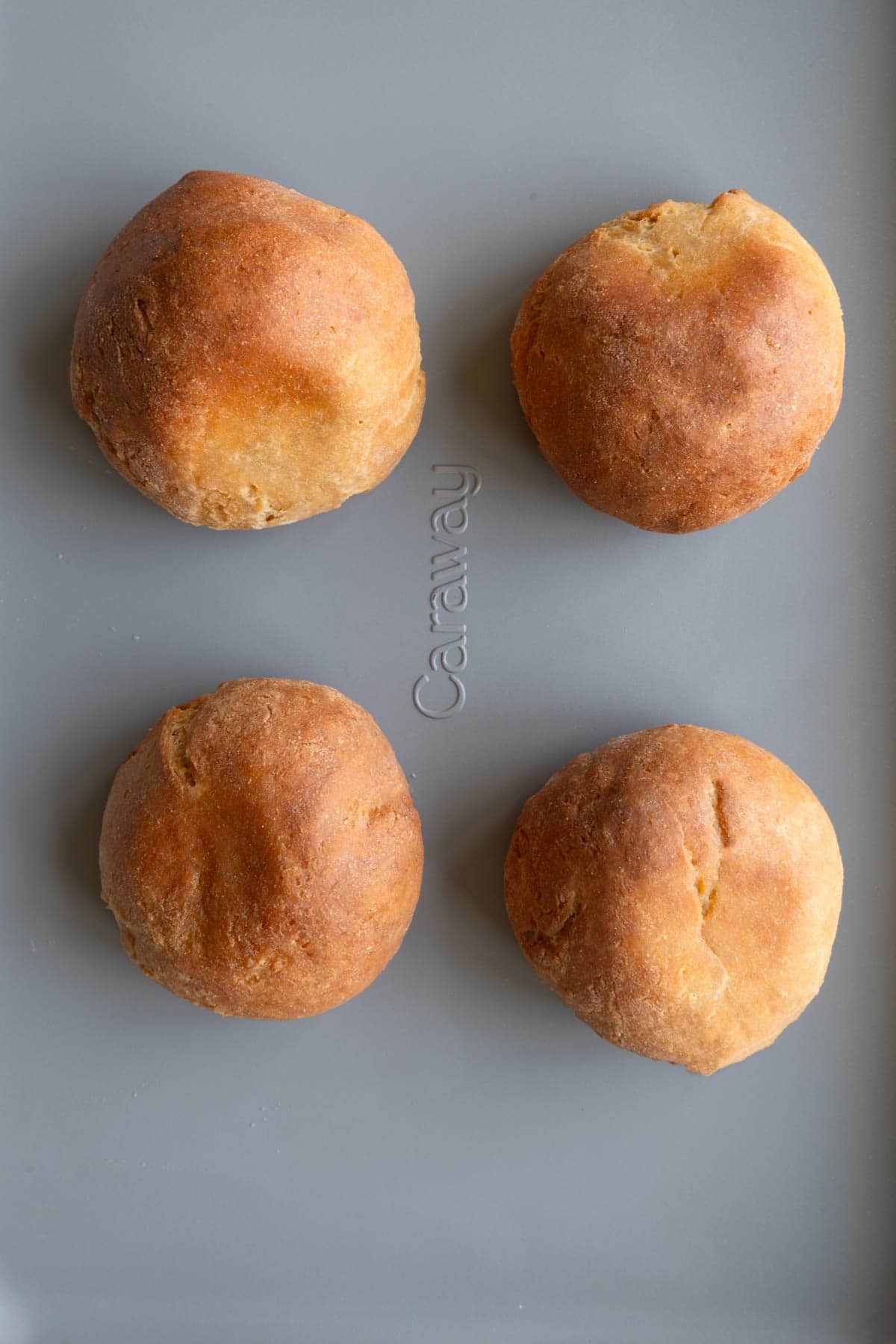 4 high-protein bread rolls on a baking sheet.