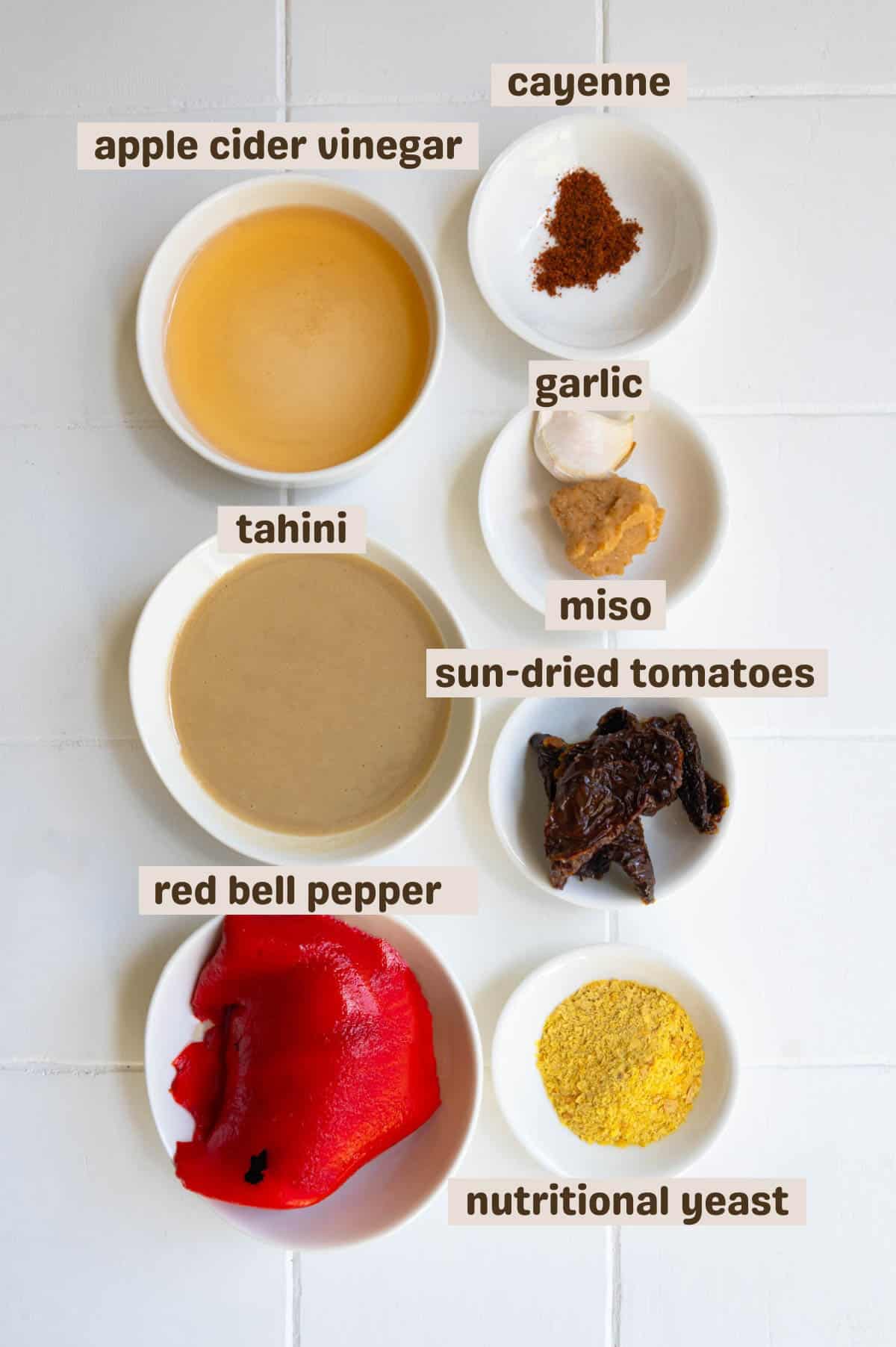 Sun-dried tomatoes, roasted red bell pepper, tahini, nutritional yeast, garlic, and vinegar in a jar.