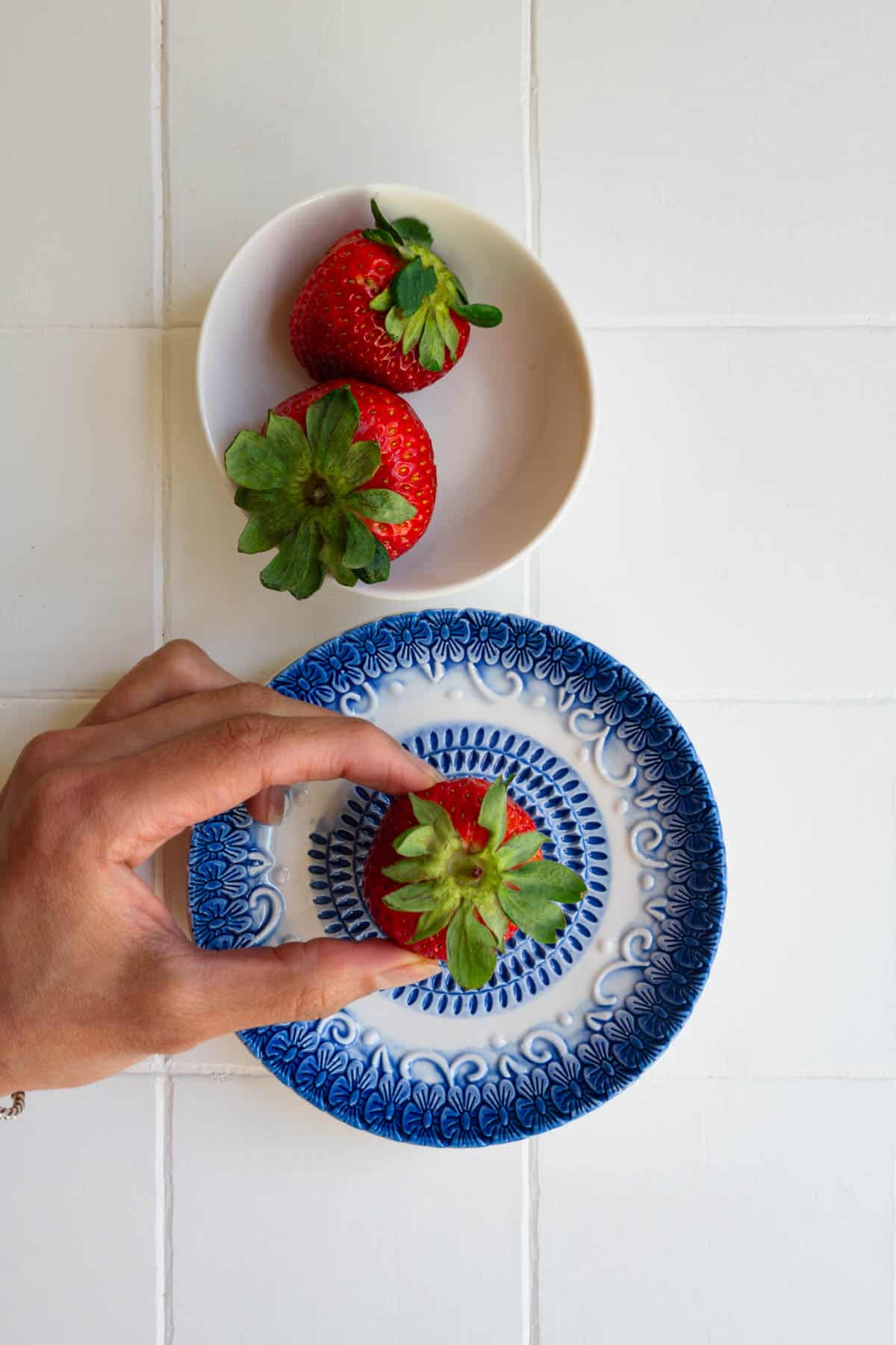 A ceramic garlic grater plate with fresh strawberry.