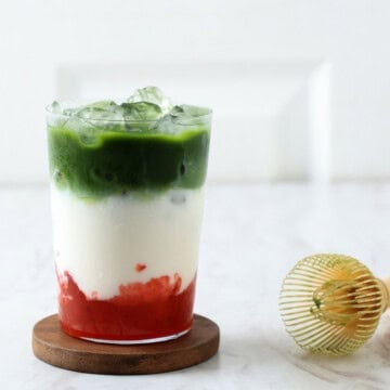 Strawberry matcha latte in a glass with ice.