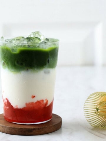 Strawberry matcha latte in a glass with ice.
