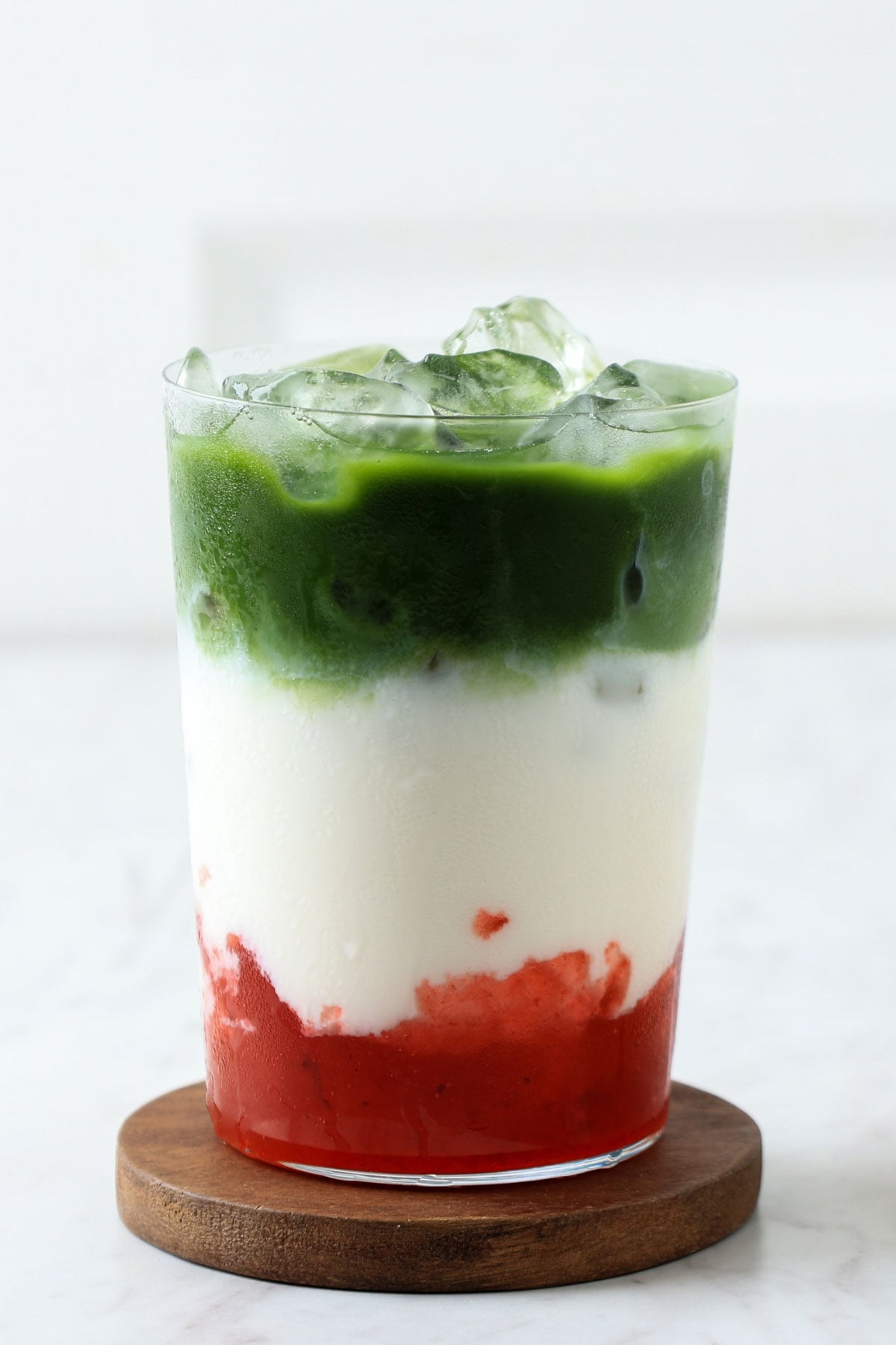 Strawberry matcha latte in a glass with ice.