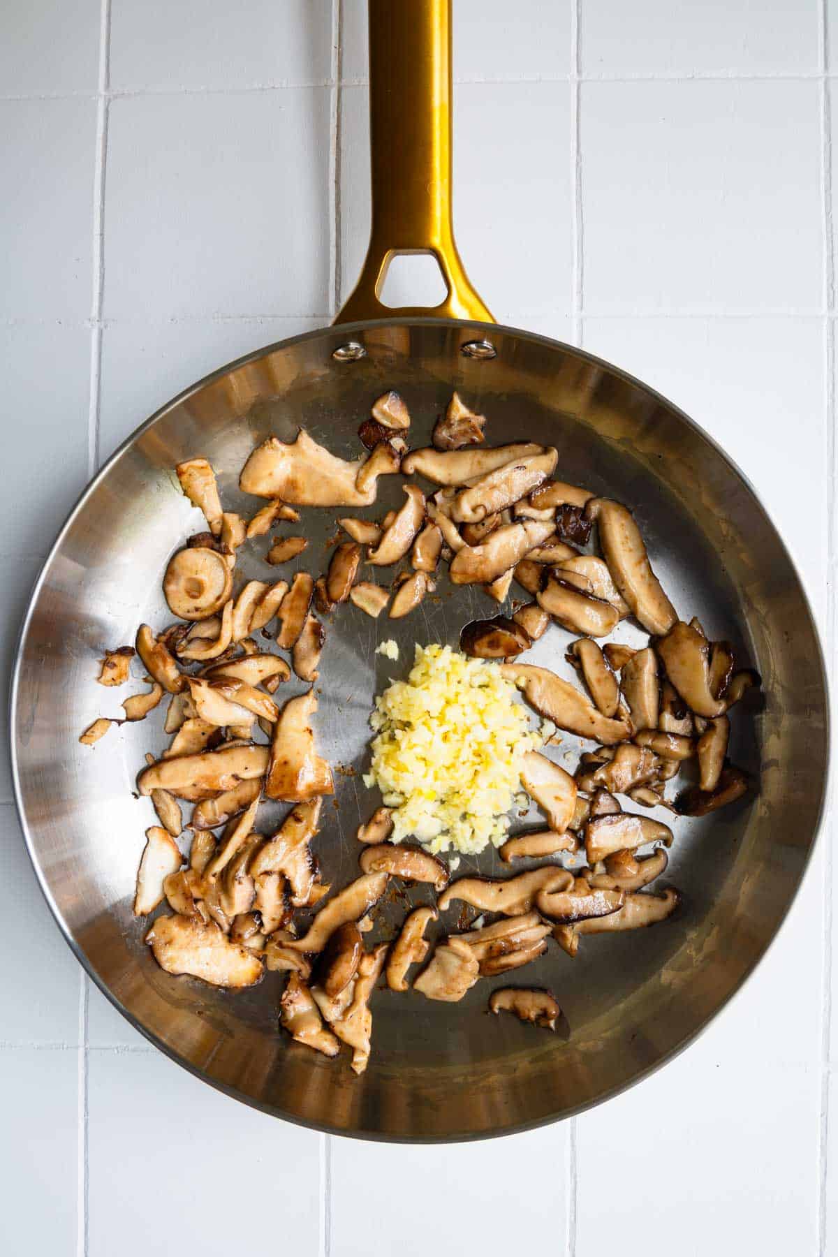 Sautéed mushroom with garlic and ginger in a skillet.
