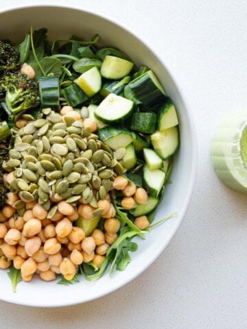 Green goddess arugula salad with chickpeas, roasted broccolini, cucumber, and pumpkin seeds.