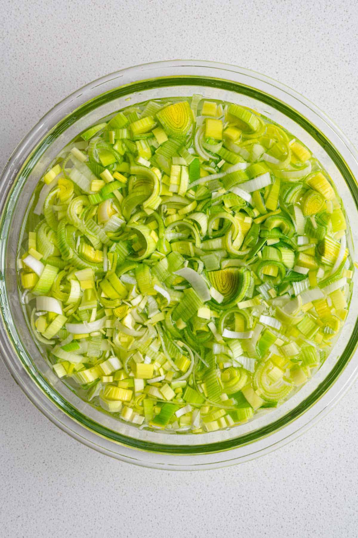 Chopped leeks in a bowl of water.