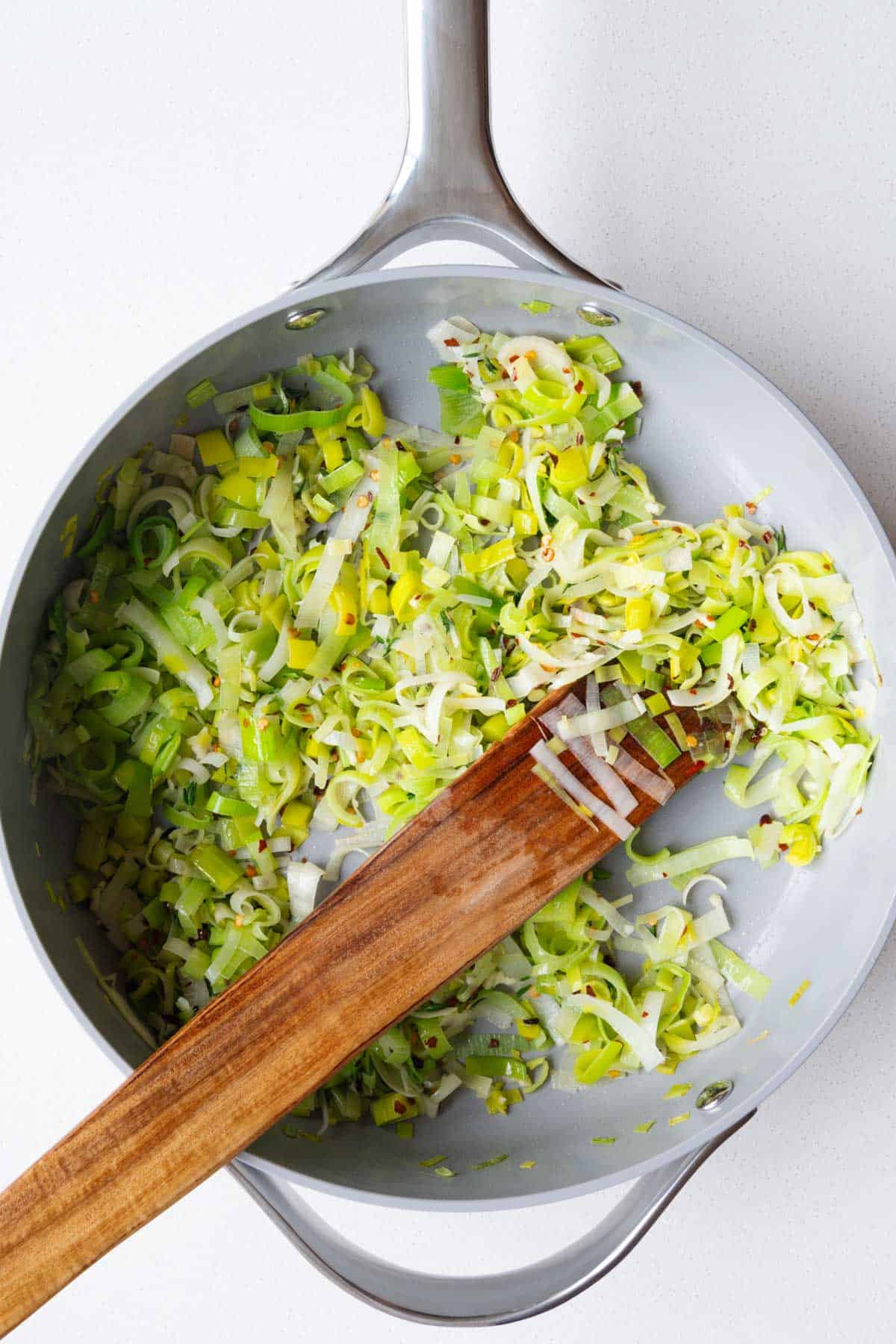 Chopped leek cooking in a skillet.