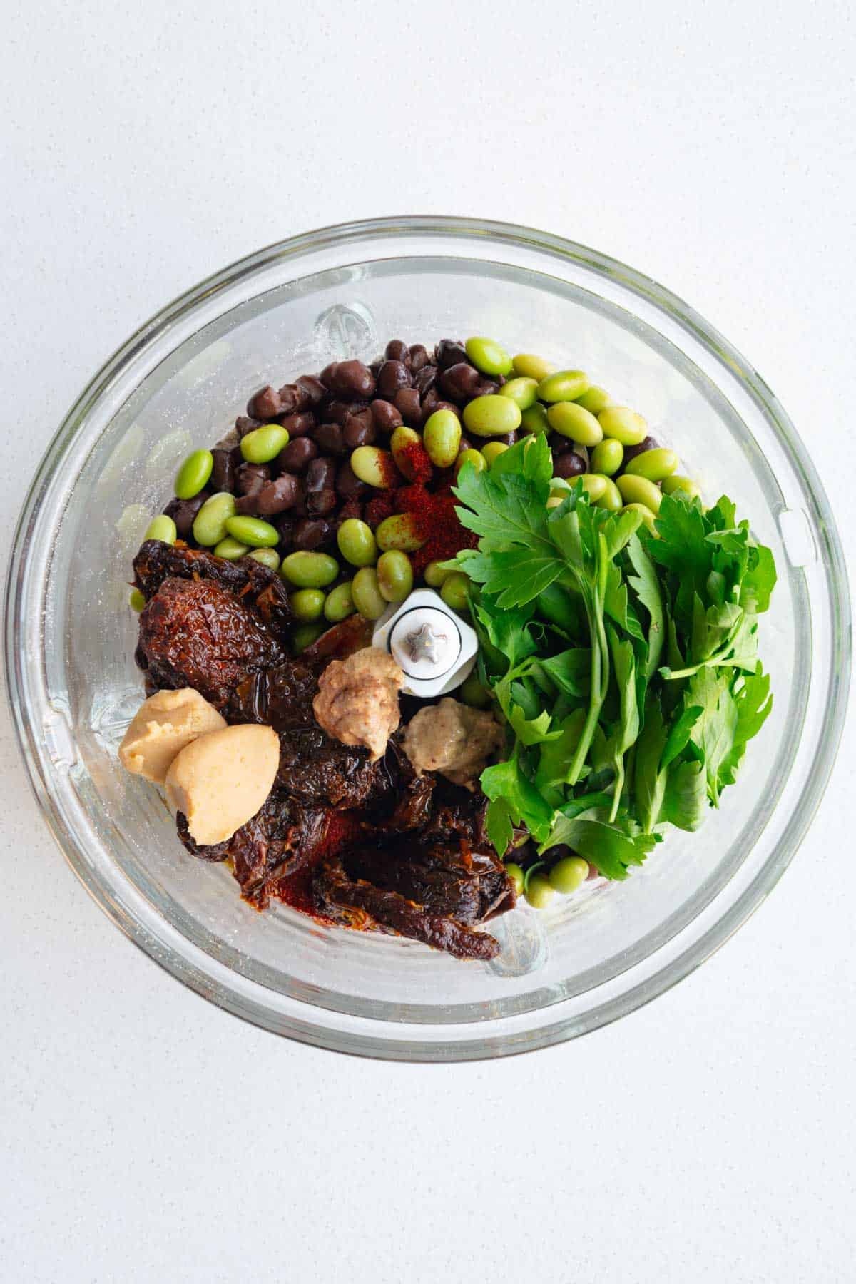 Edamame, black beans, sun-dried tomatoes, parsley, miso, dijon, and smoked paprika in a food processor.