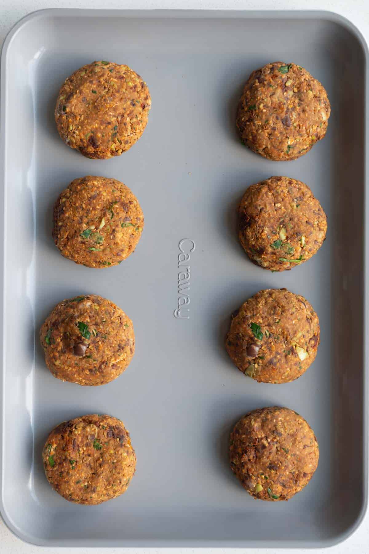 Eight patties on a baking sheet.