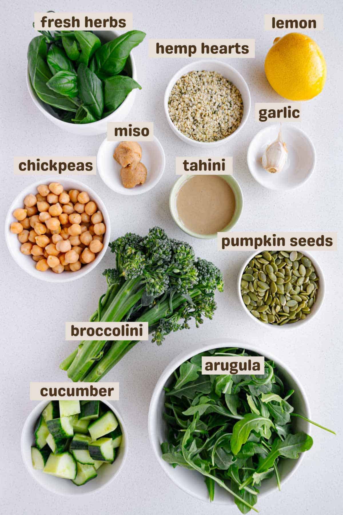 Fresh herbs, hemp hearts, lemon, garlic, miso, tahini, chickpeas, broccolini, cucumber, arugula, and pumpkin seeds.