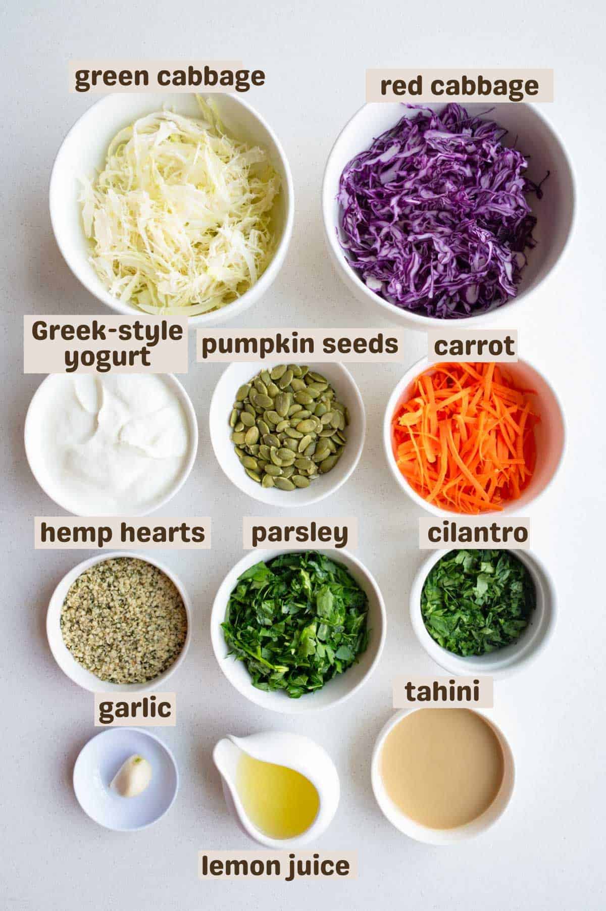 Green cabbage, red cabbage, Greek-style yogurt, pumpkin seeds, hemp hearts, carrot, parley, cilantro, tahini, garlic, and lemon juice.