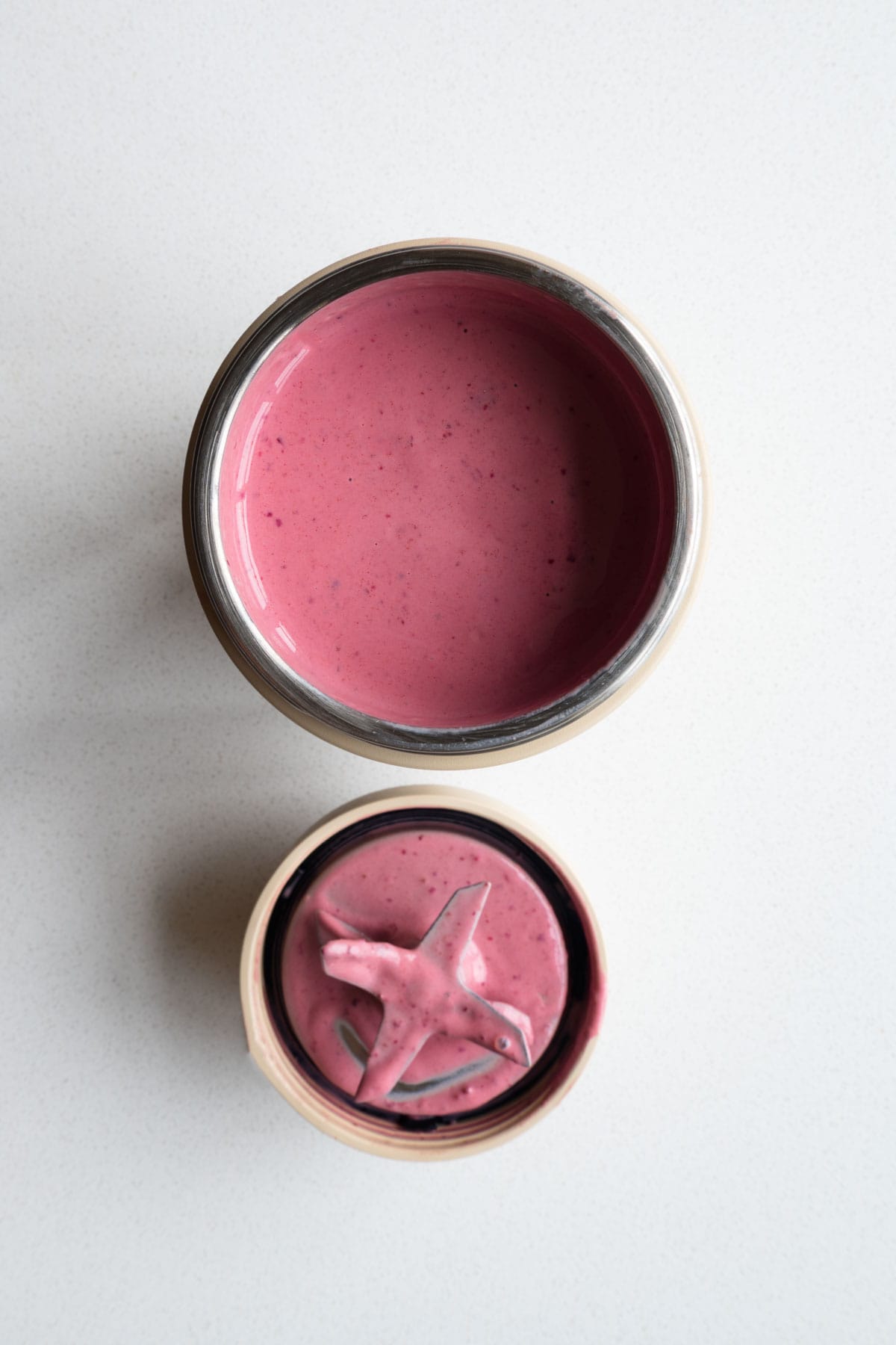Blended pink smoothie in the canister of a blender.