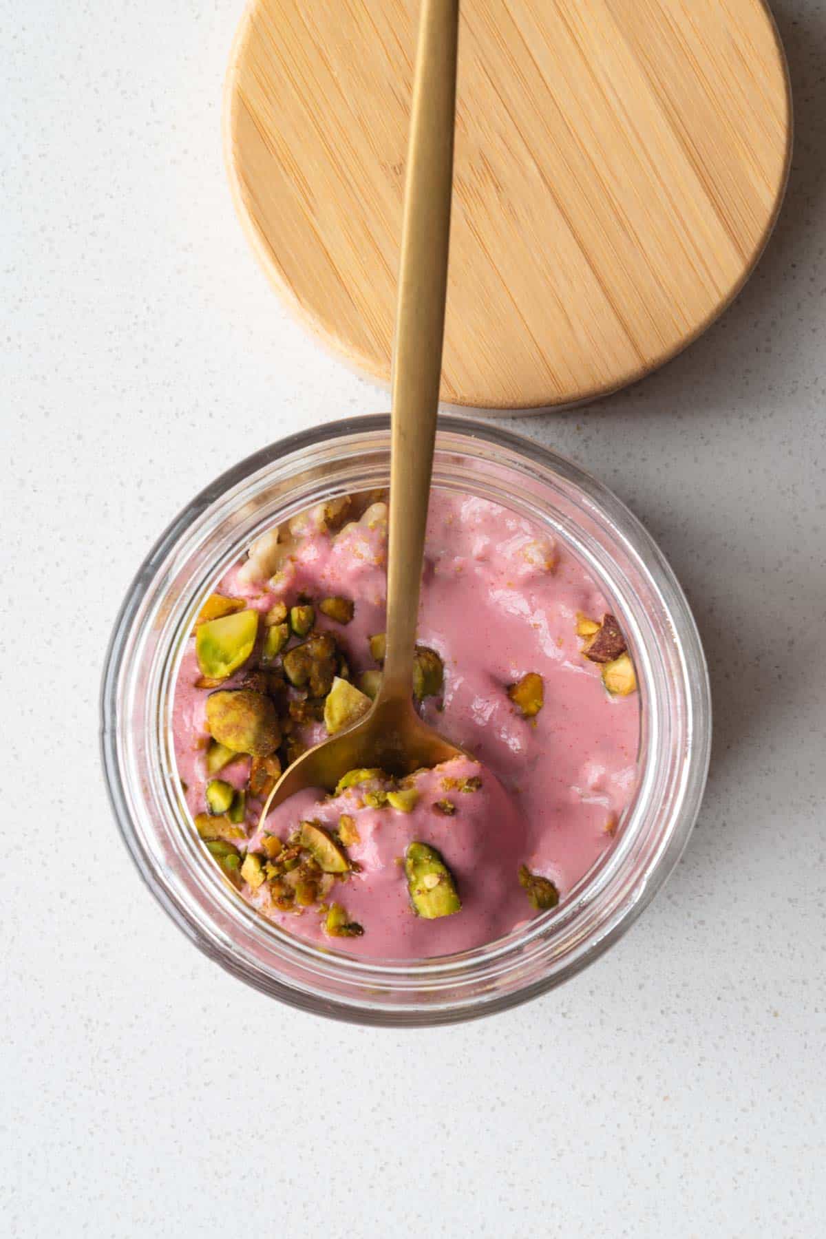 Oat groats parfait in a jar with a spoon.