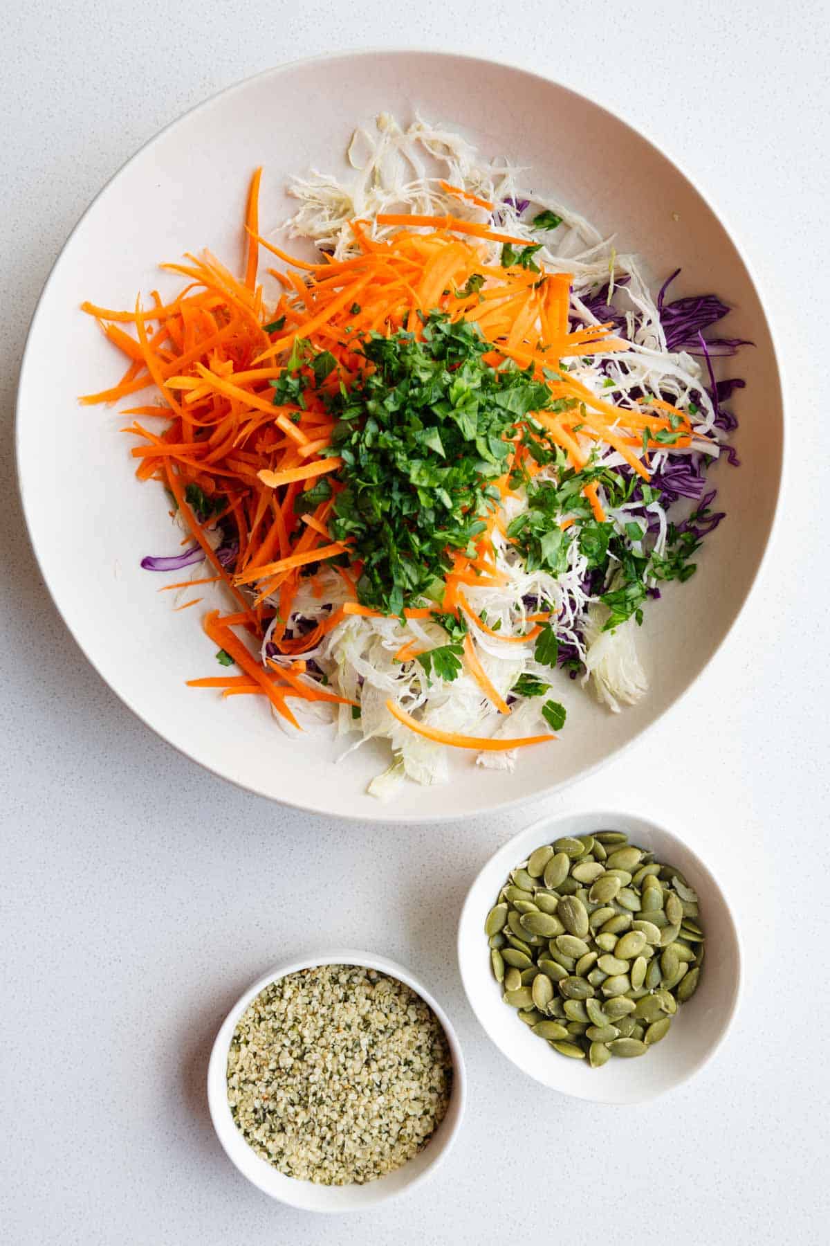 Grated purple cabbage, carrot, green cabbage, fresh herbs, hemp hearts, and pumpkin seeds.