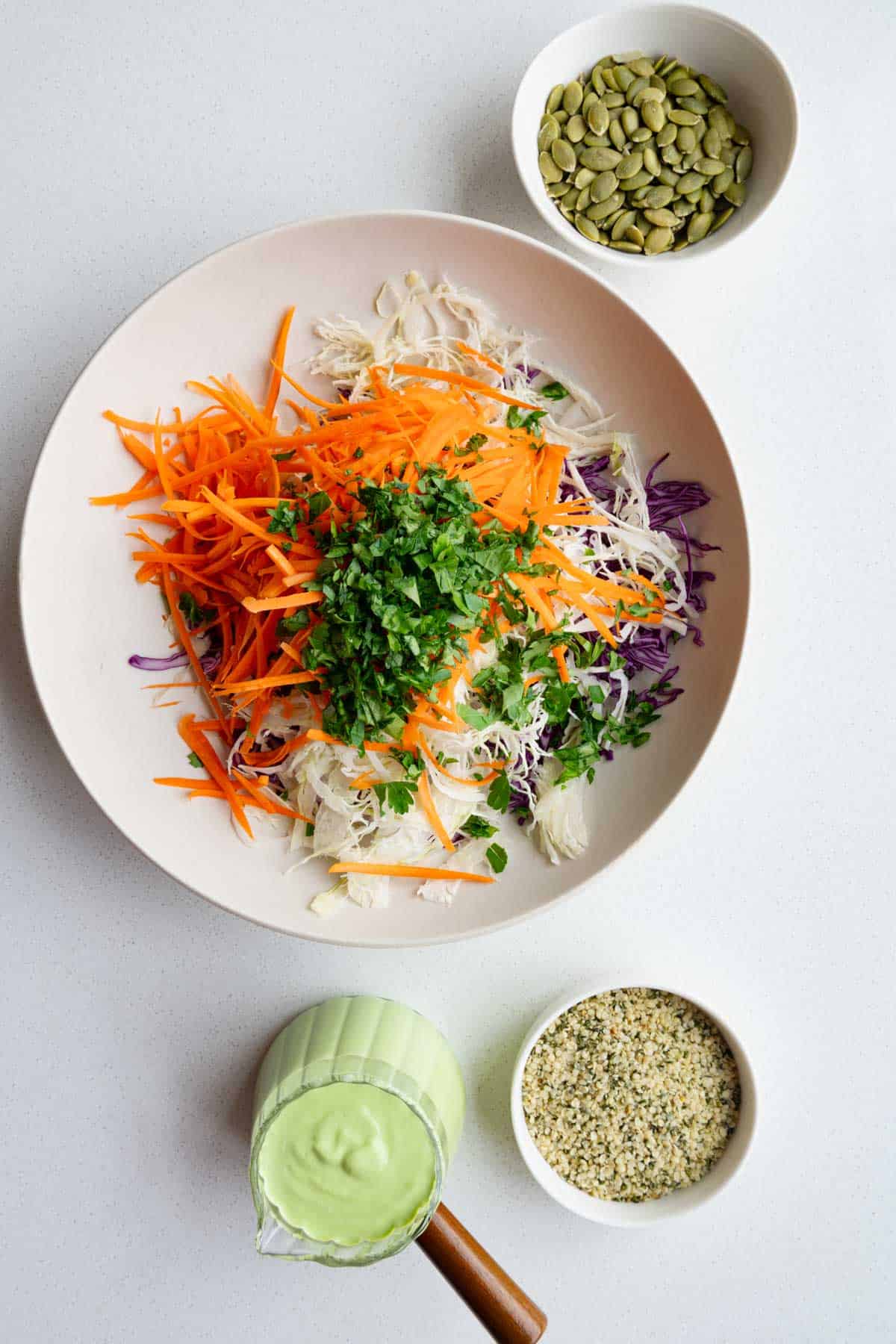 Grated purple cabbage, carrot, green cabbage, fresh herbs, green goddess coleslaw dressing, hemp hearts, and pumpkin seeds.