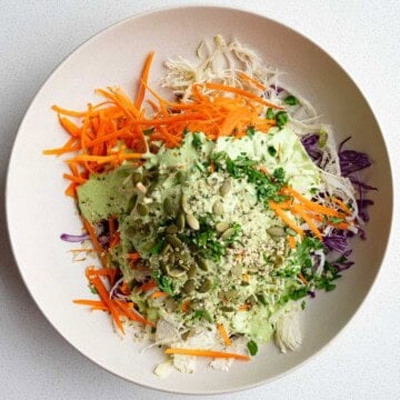 Red cabbage coleslaw with a drizzle of creamy mayo-free dressing on top.