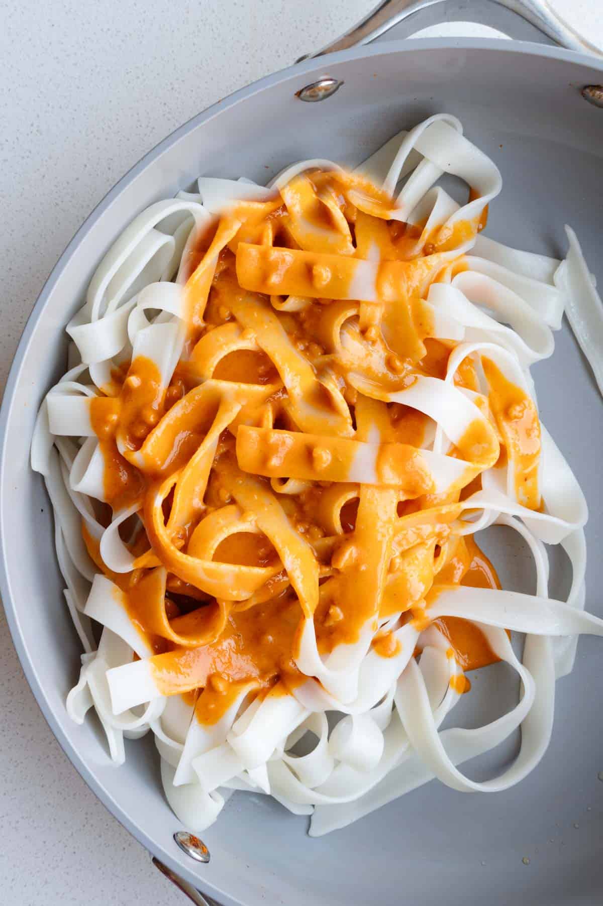 Thai tofu marinade in a skillet with noodles as a sauce.
