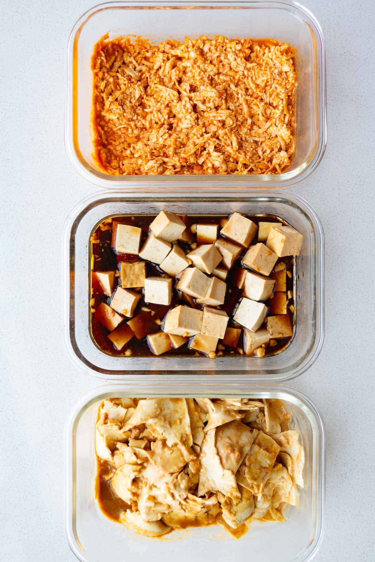 Grated, cubed, and thinly sliced tofu in three different sauces.