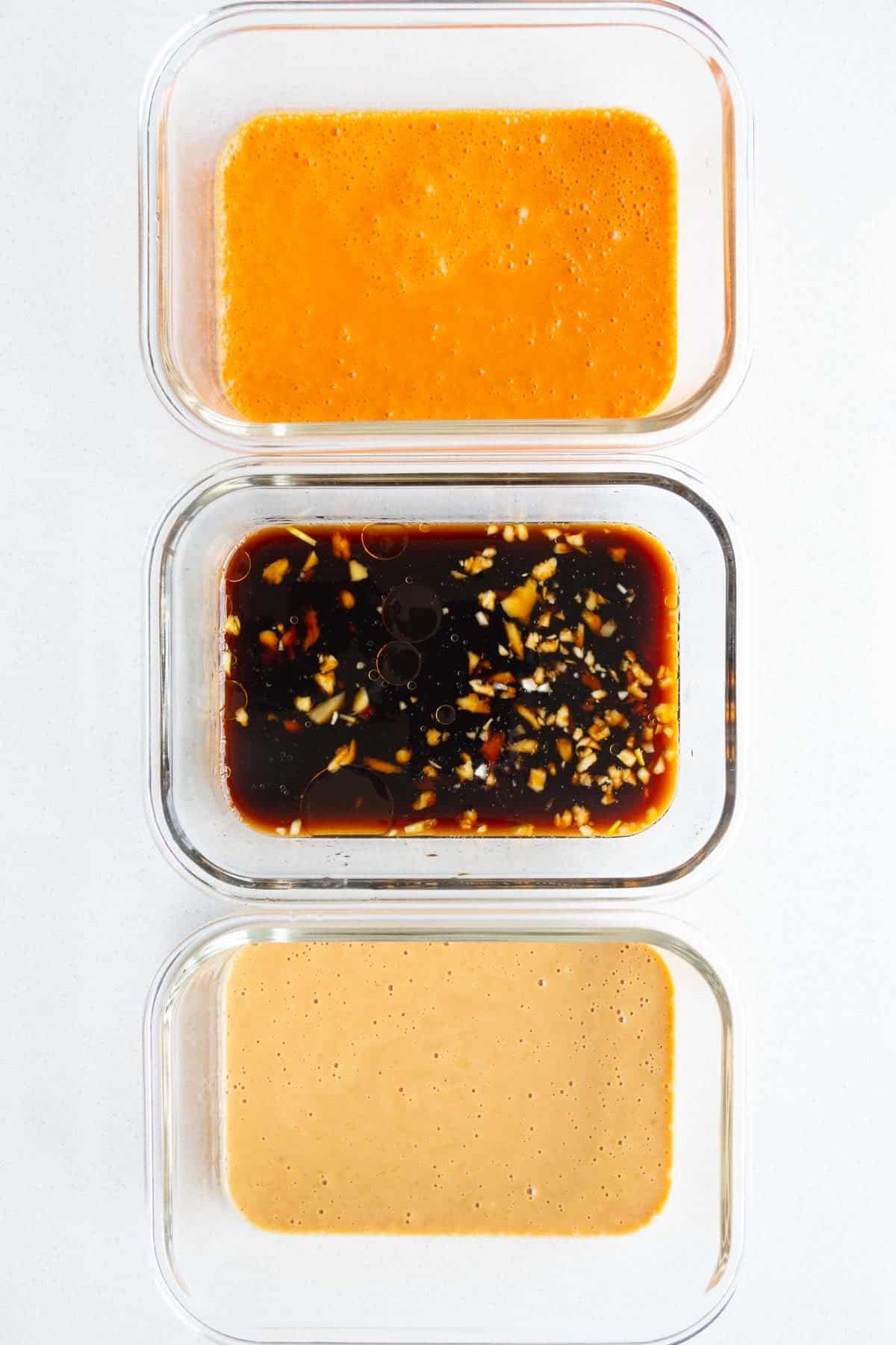 Thai tofu marinade, soy tofu marinade, and creamy peanut marinade in three glass dishes.