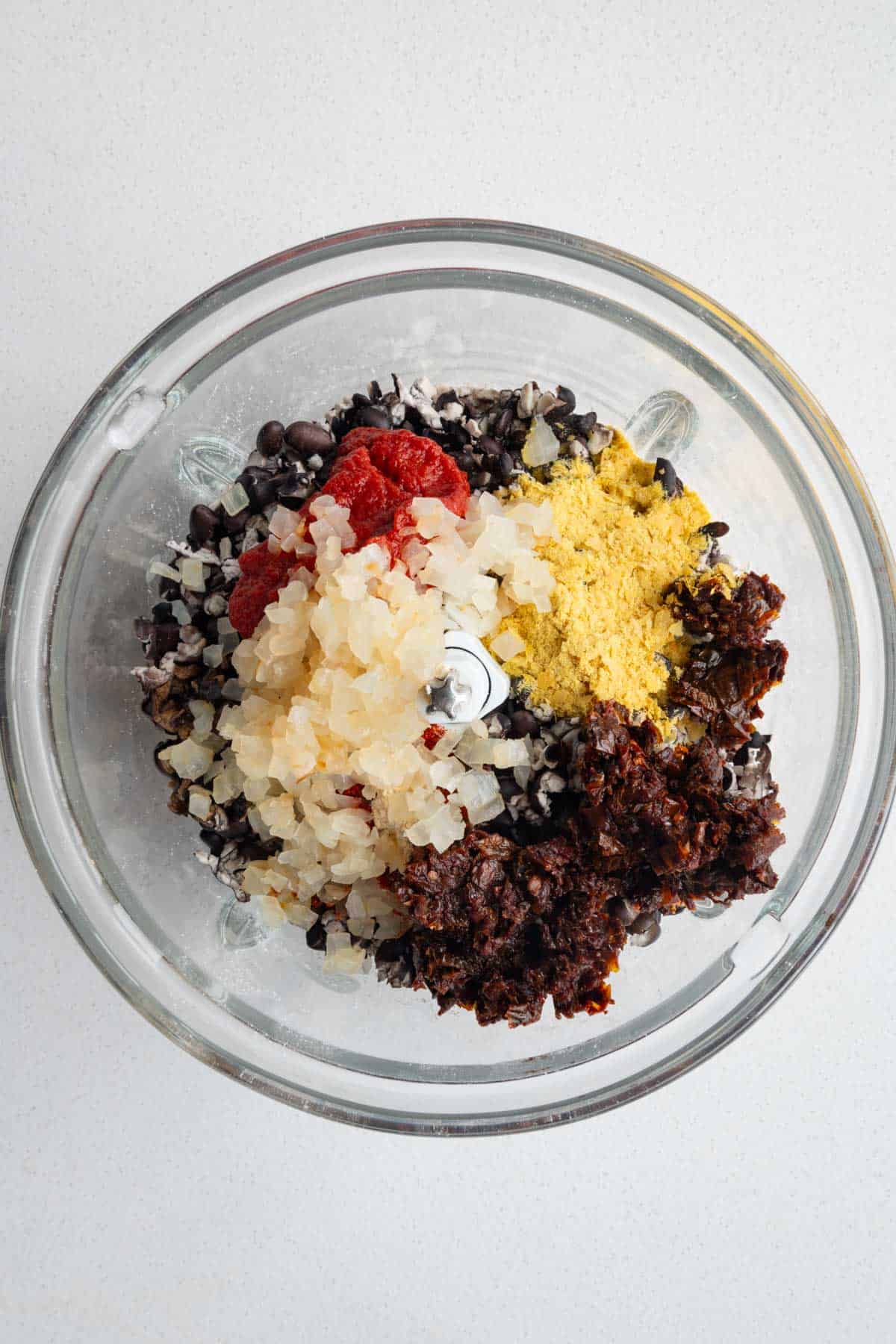 Baked black soybeans, tomato paste, ground oats, cooked onion, nutritional yeast, sun-dried tomatoes, and seasoning.