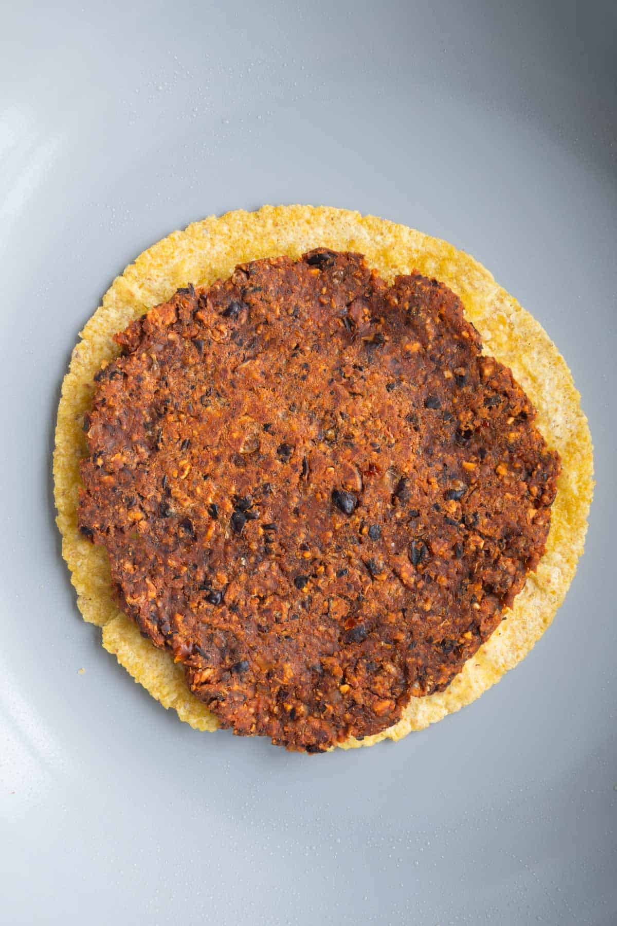 Smashed burger on a corn tortilla.