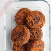 Black soybean burgers in a glass storage dish.