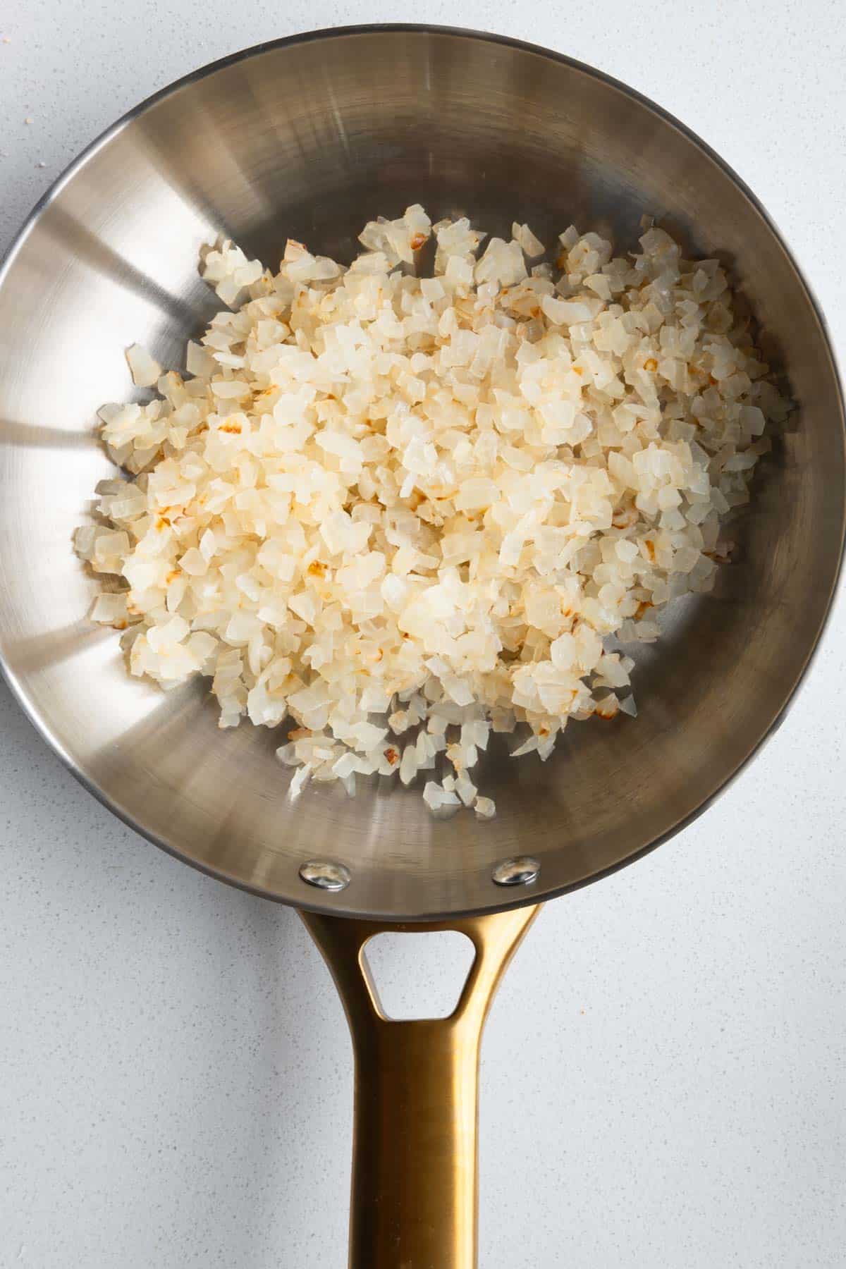 Cooked onion in a steel skillet.