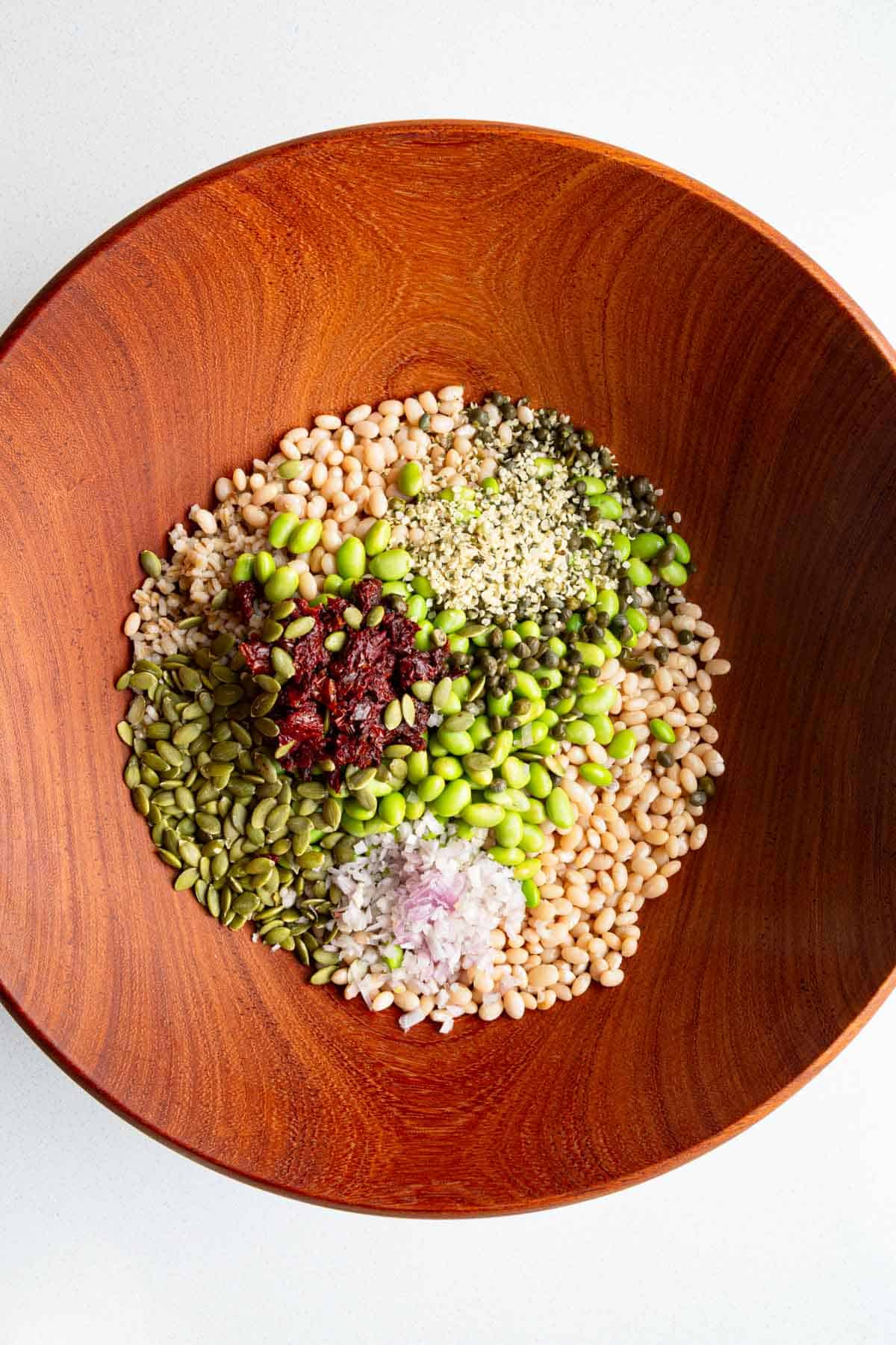 White beans, barley, edamame, sun-dried tomatoes, shallots, capers, hemp hearts, and pumpkin seeds.