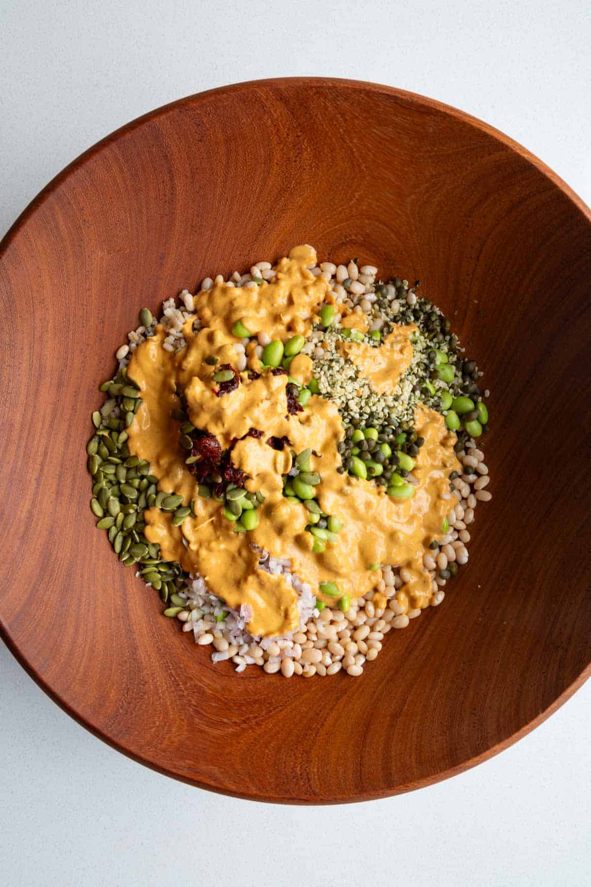 White beans, barley, edamame, sun-dried tomatoes, shallots, capers, hemp hearts, and pumpkin seeds with harissa dressing.