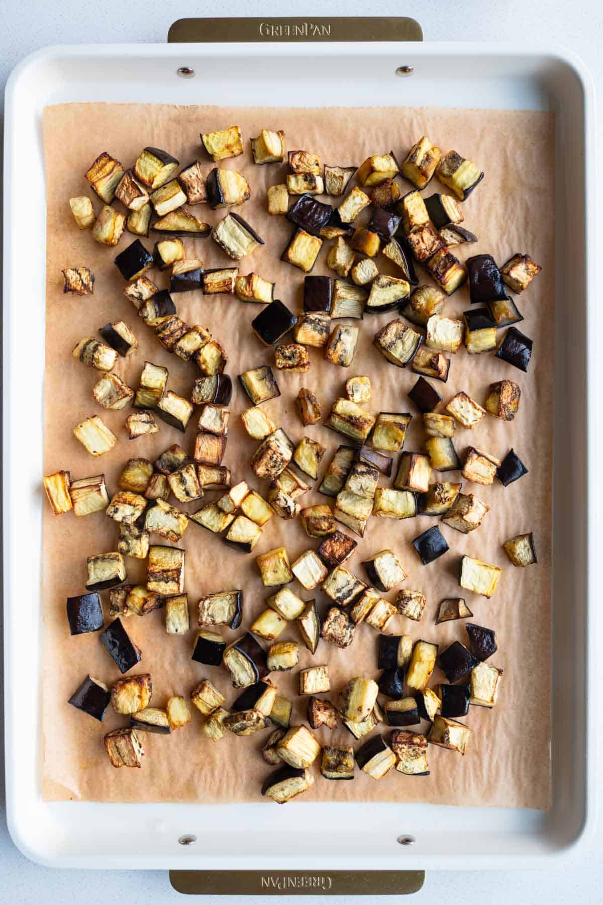 Roasted eggplant on a parchment-lined baking sheet.