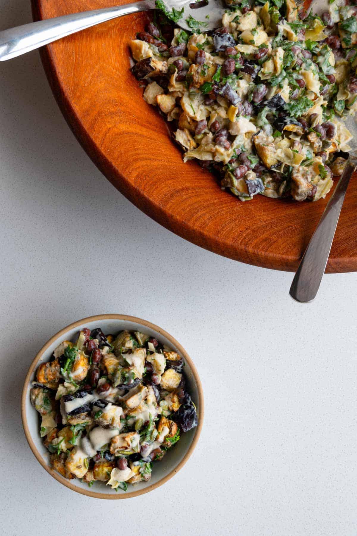 Eggplant salad in a large wooden bowl and in a small serving bowl.
