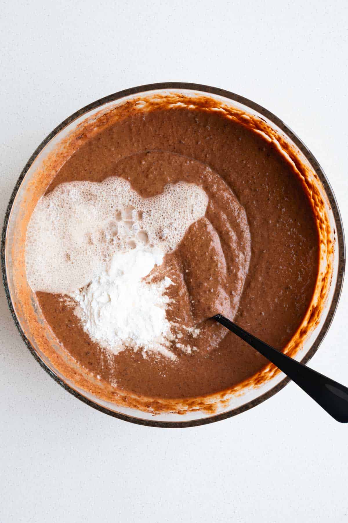 Cake batter with baking soda, baking powder, and apple cider vinegar on top.