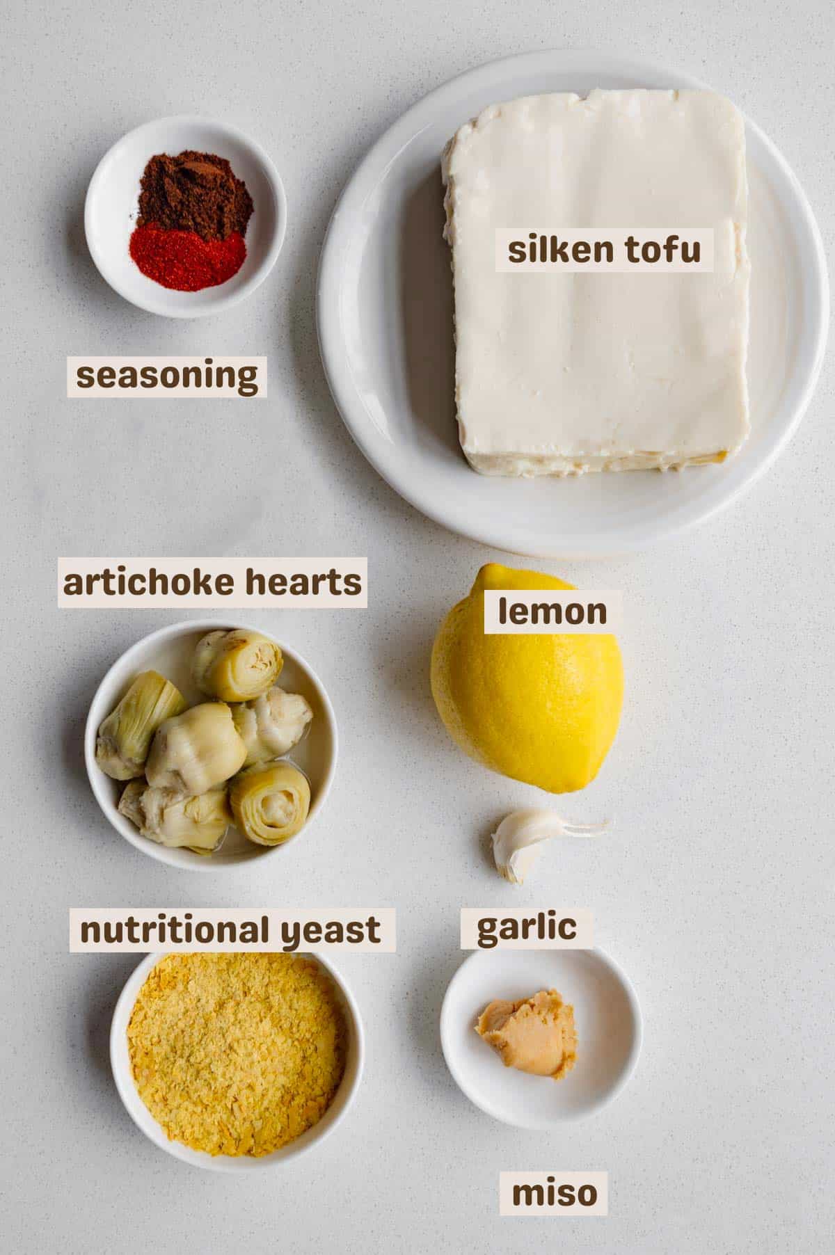Seasoning, silken tofu, artichoke hearts, lemon, garlic, nutritional yeast, and miso.