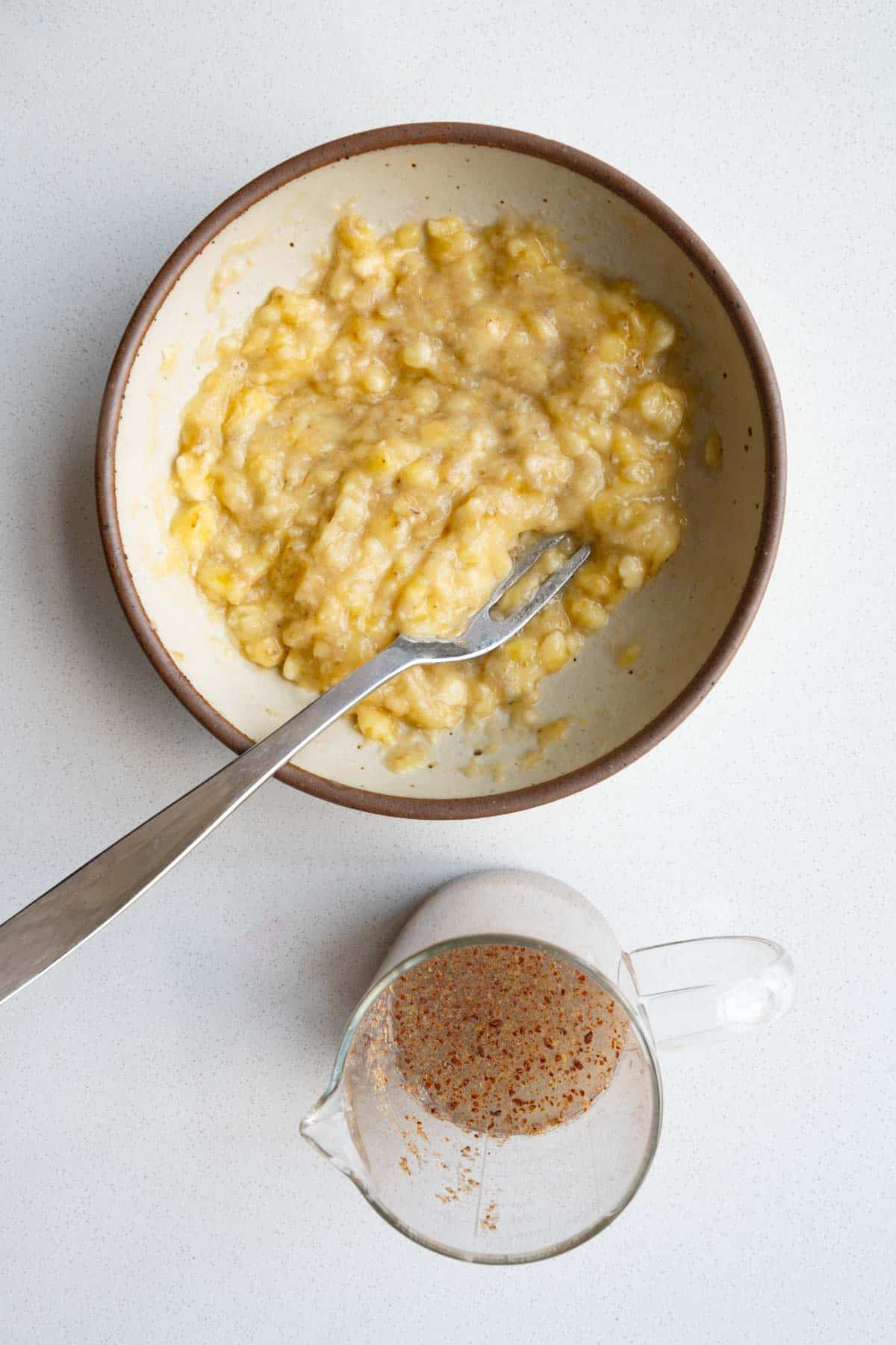 Mashed bananas in a bowl and a flax egg.
