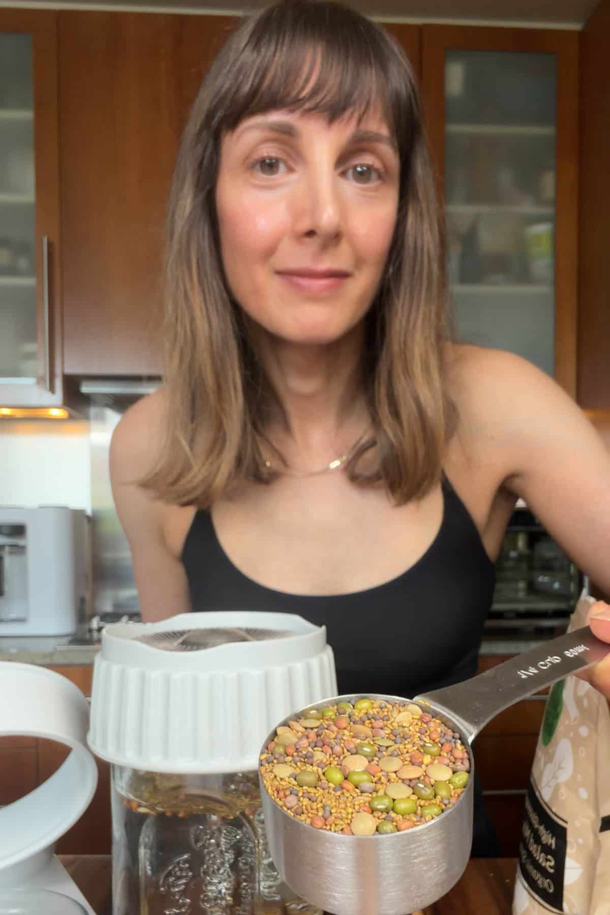 Nisha holding a measuring cup with high-glucoraphanin sprout seed salad mix.