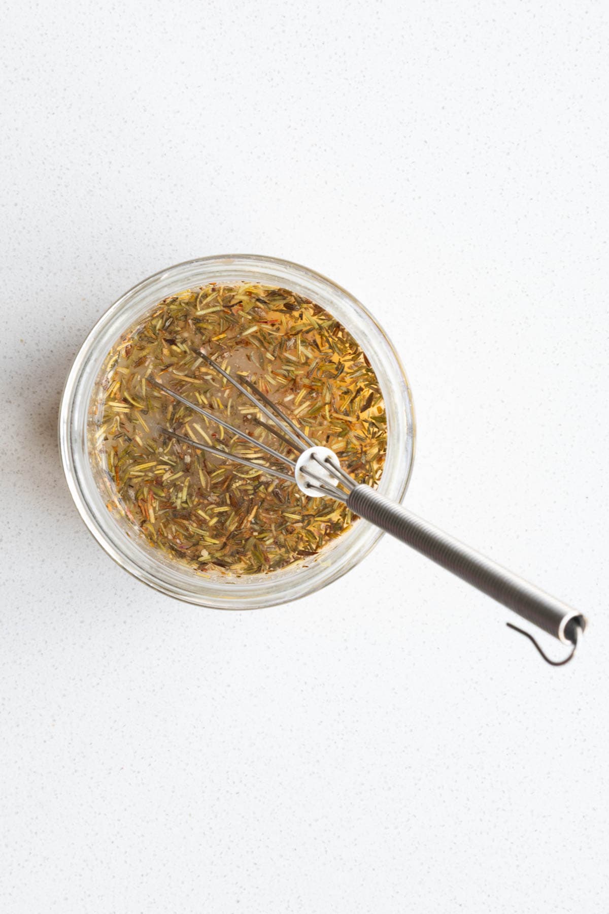 Pickle juice, lemon juice, garlic, mustard, miso, dried herbs, and onion powder in a glass jar with a whisk.