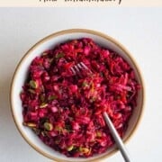 Beetroot salad with pomegranate in a bowl with a fork.