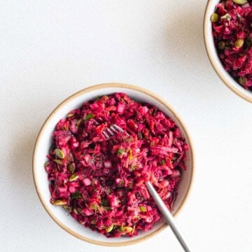 Beetroot salad with pomegranate in a bowl with a fork.