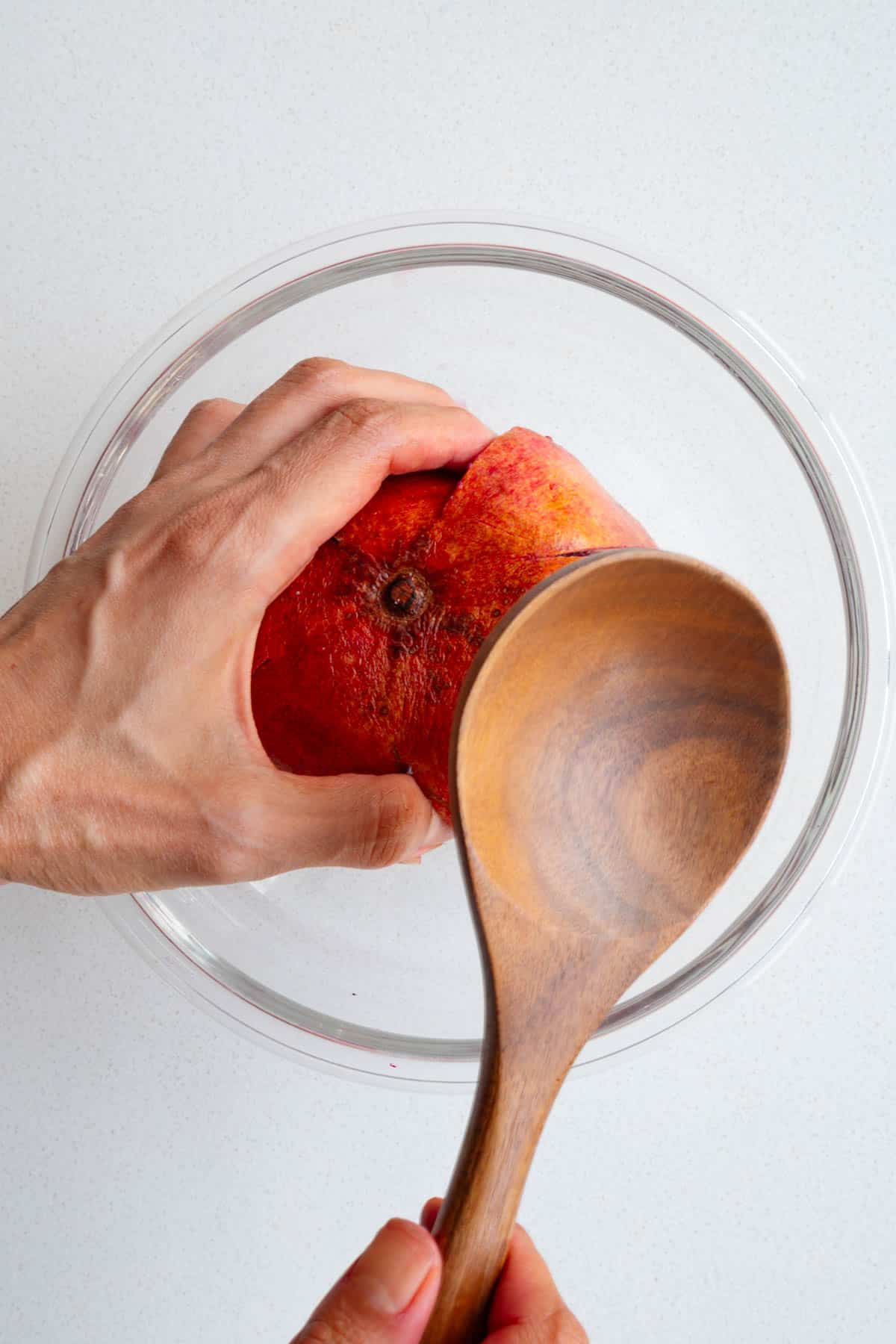 Hitting the back of a pomegranate with a wooden spoon.