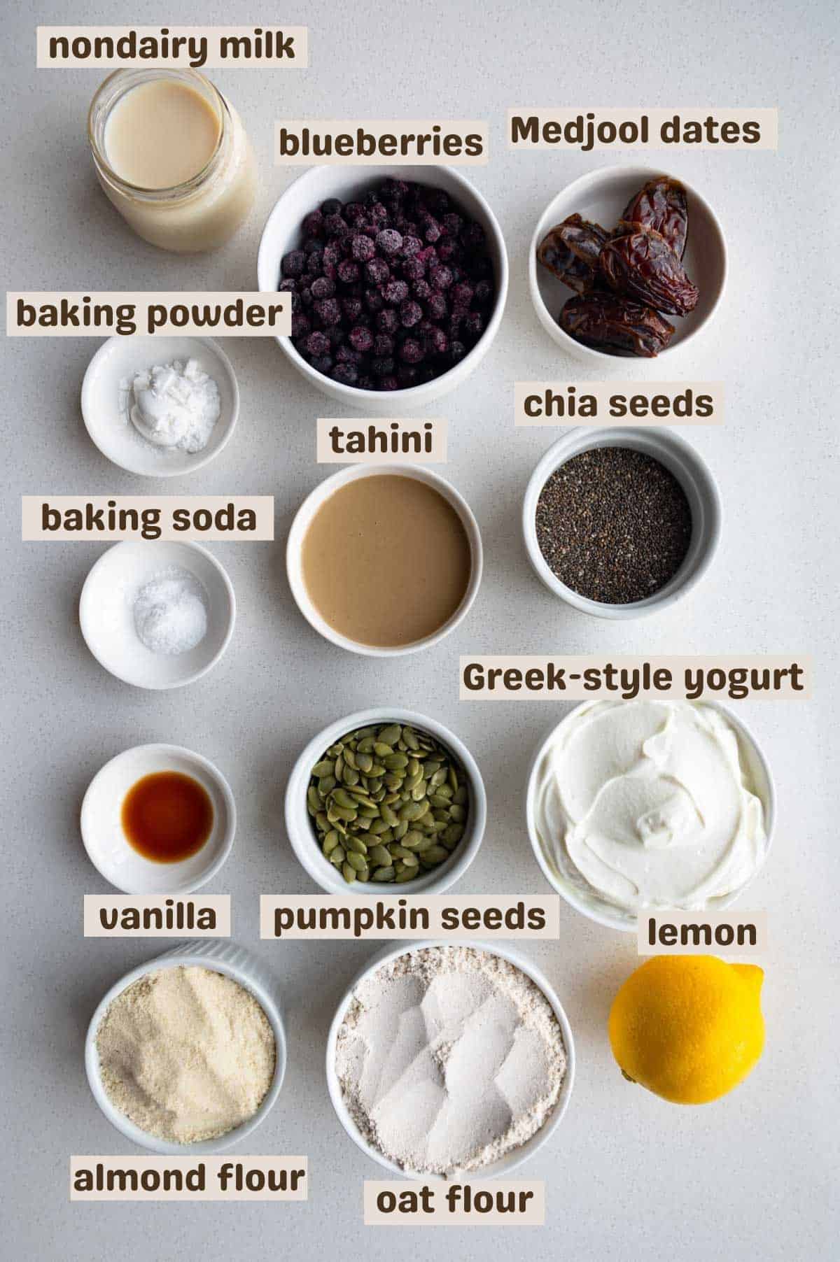 Nondairy milk, frozen blueberries, Medjool dates, baking powder, baking soda, tahini, chia seeds, vanilla extract, pumpkin seeds, lemon, almond flour, oat flour, and Greek-style yogurt.