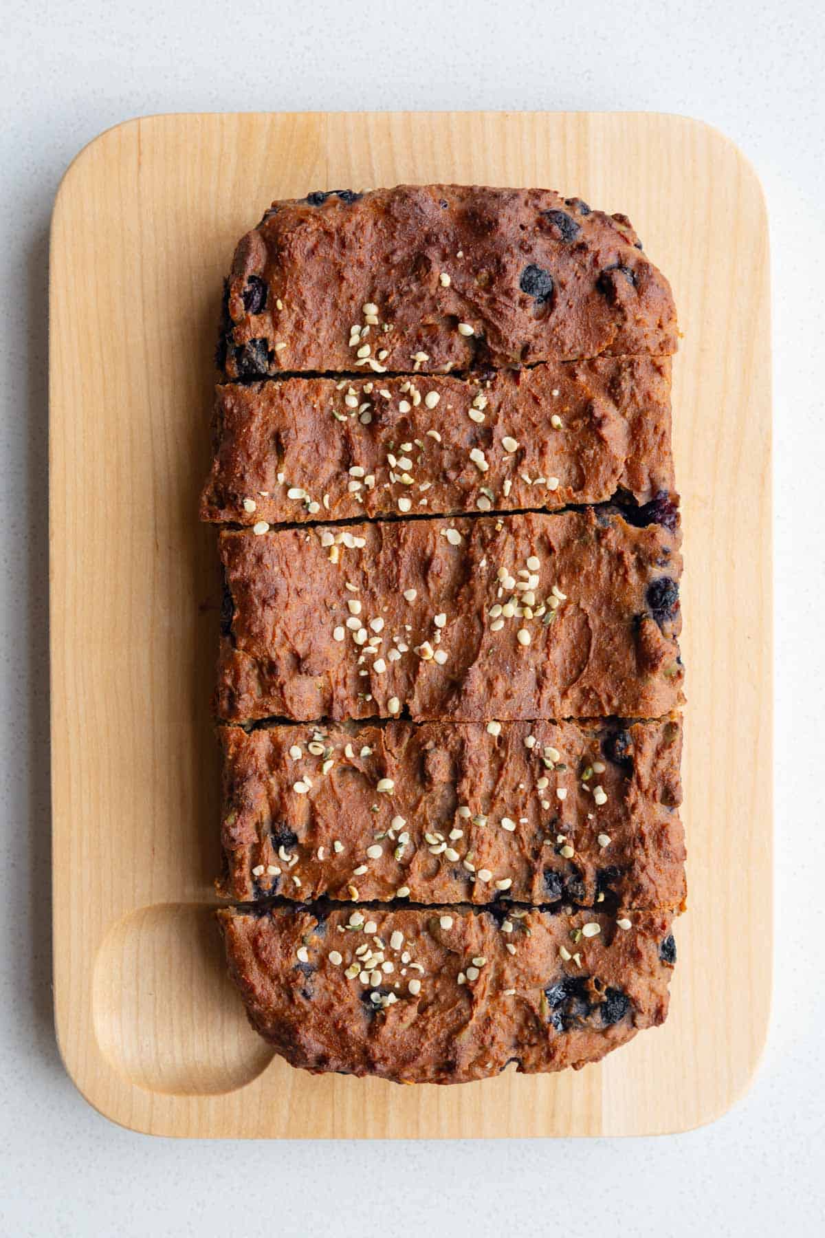 High-protein lemon blueberry loaf with chia seeds on a cutting board.