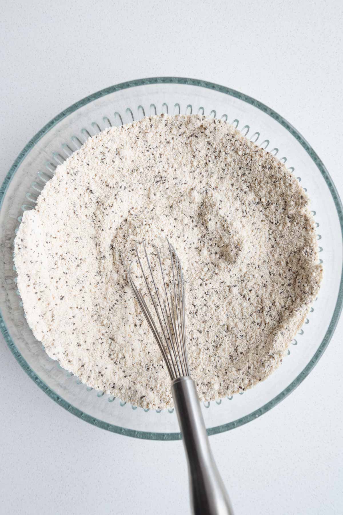 Dry ingredients whisked in a glass bowl.