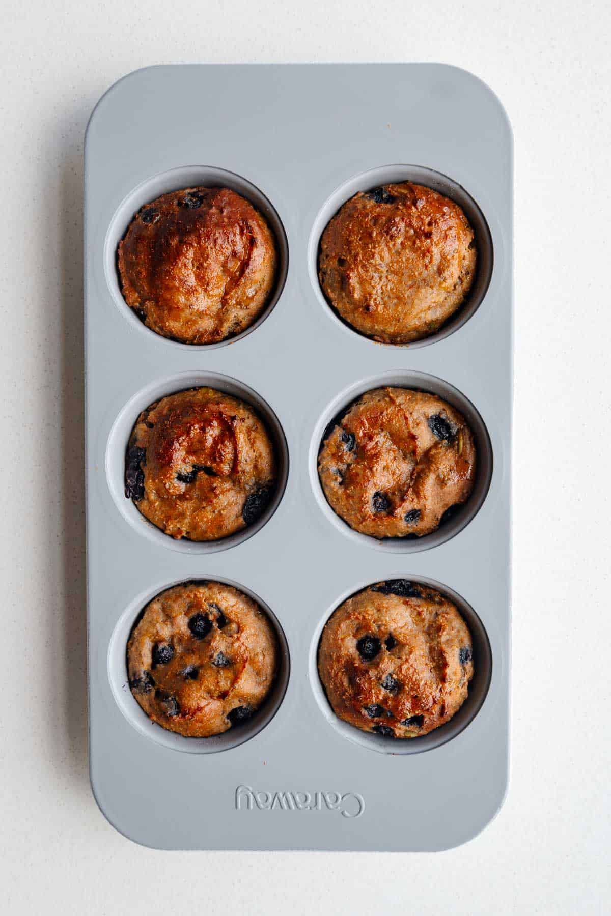 High-protein lemon blueberry muffins in a muffin tin.