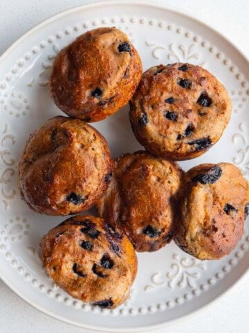 Healthy lemon blueberry muffins with yogurt and chia seeds on a white plate.