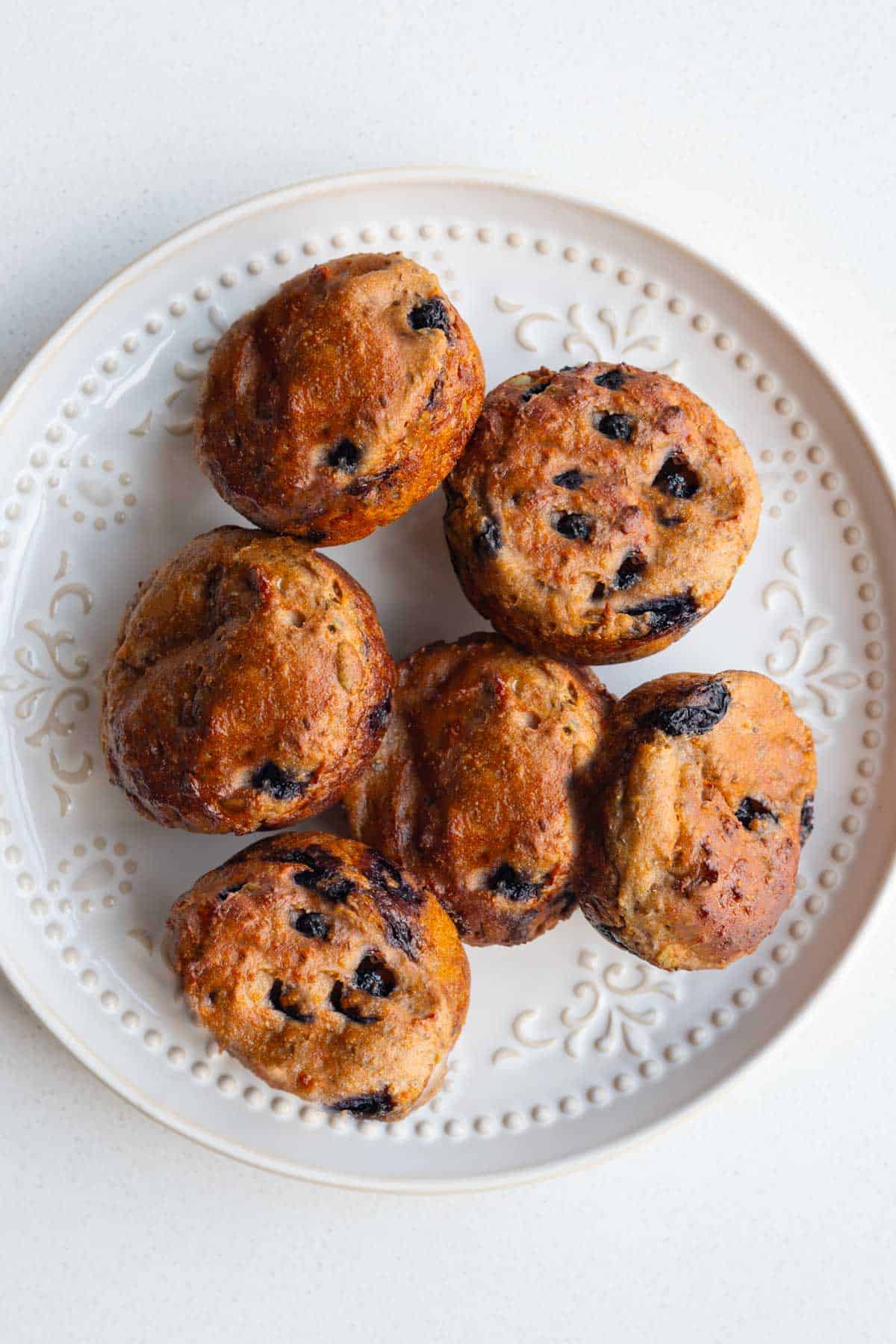 Healthy lemon blueberry muffins with yogurt and chia seeds on a white plate.