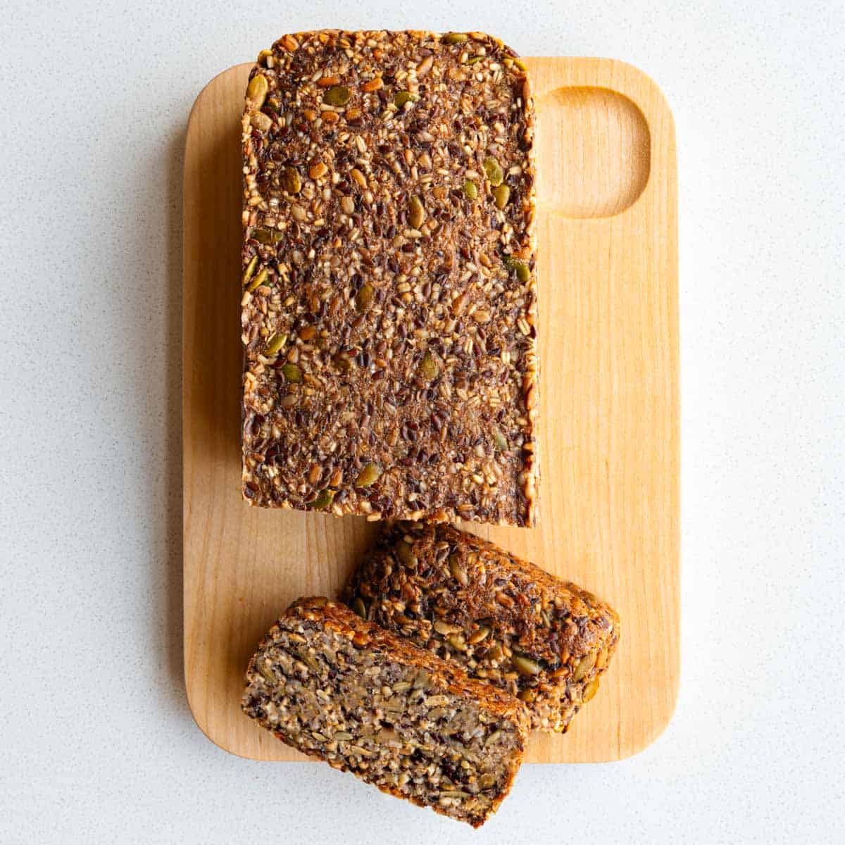 Gluten-free Porridge Bread (Seed Bread) made with no yeast sliced on a cutting board.