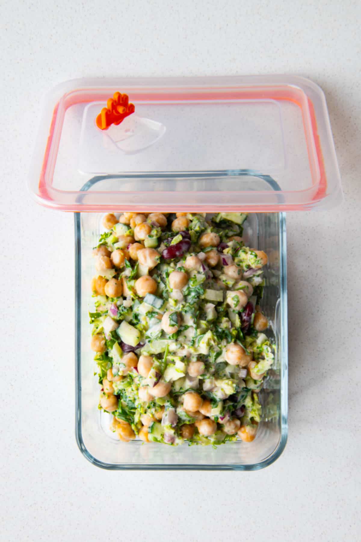 Creamy broccoli bean salad in a meal prep container.