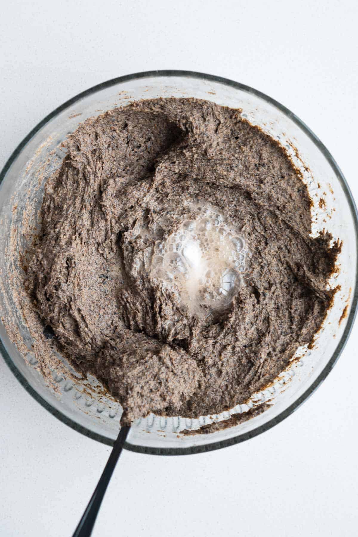 Mixing bowl with batter topped with more baking soda and apple cider vinegar.
